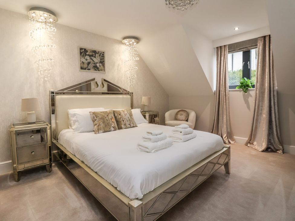 A bedroom with a bed and nightstands at Mill Race Cottage in Driffield