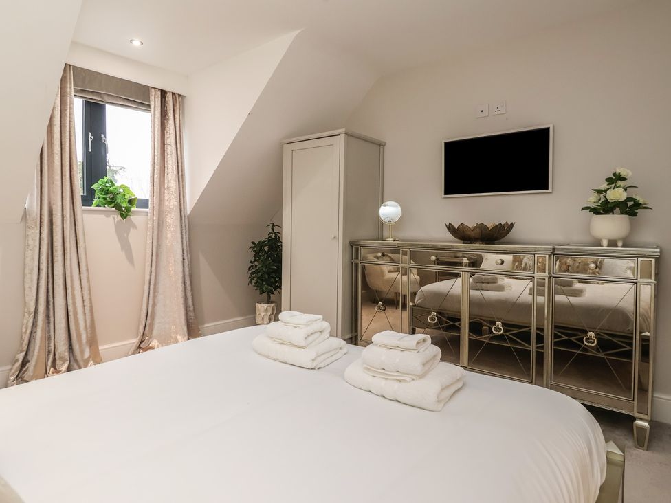 A bedroom with a bed and towels at Mill Race Cottage in Driffield