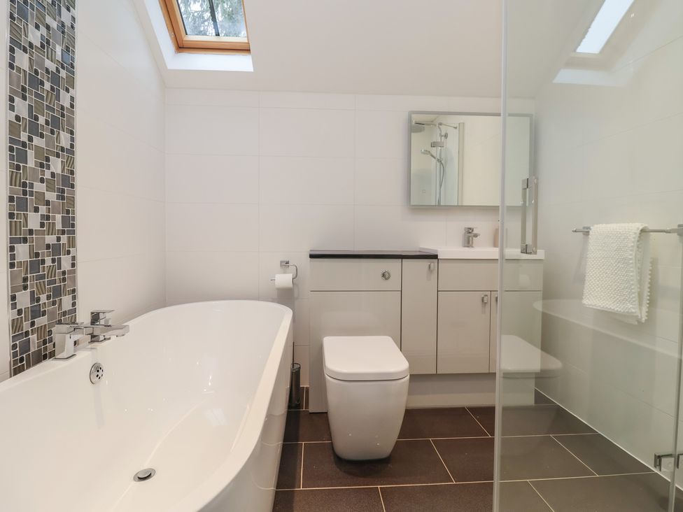 A bathroom with a bathtub and shower at Mill Race Cottage in Driffield