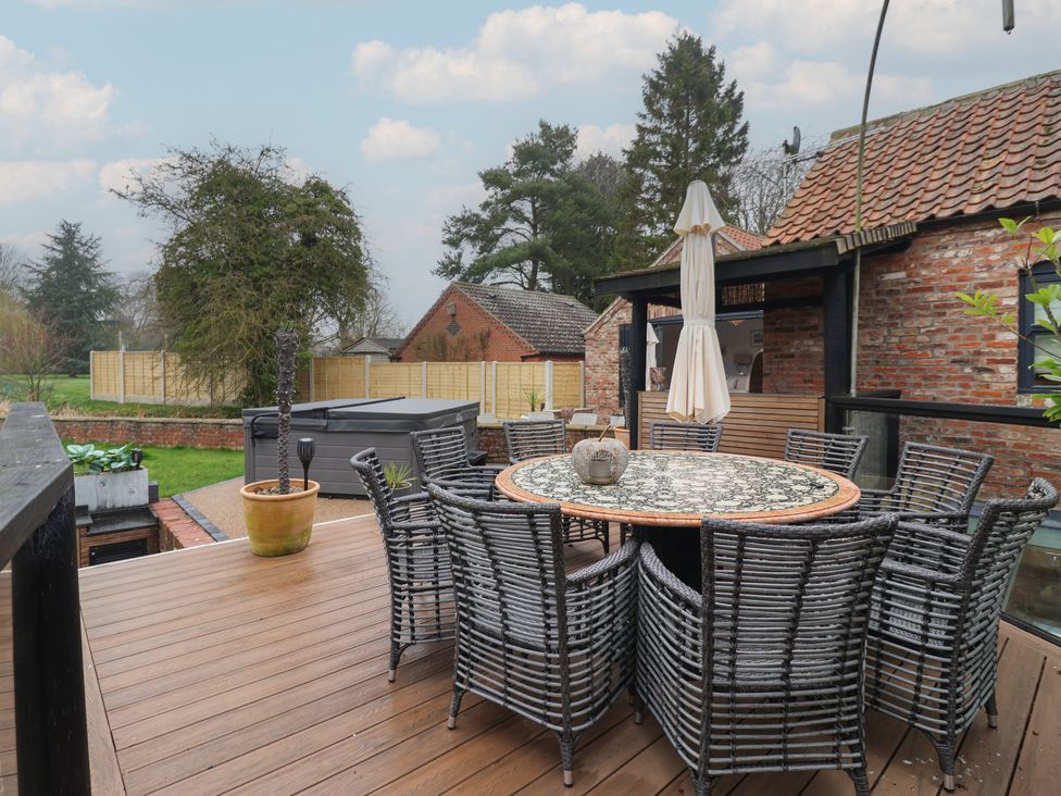 An outdoor area with a dining table and chairs at Mill Race Cottage in Driffield