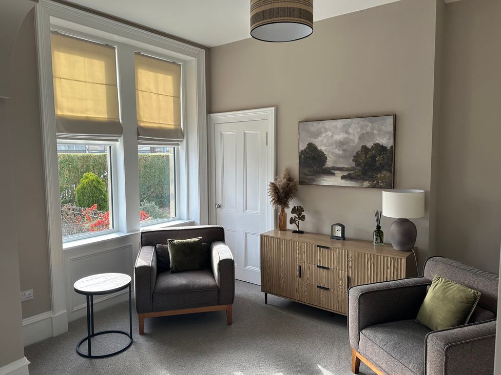 A living room with two chairs and a console table at Abbotsford in Kelso