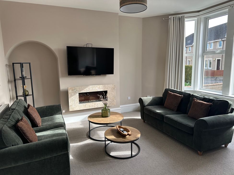 A living room with sofas and a television at Abbotsford in Kelso