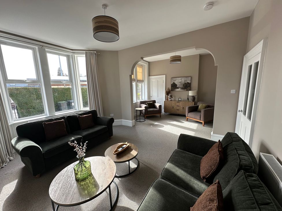 A living room with sofas, a table, and a cabinet at Abbotsford in Kelso
