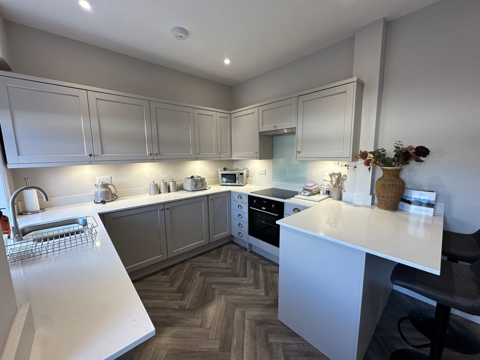 A kitchen with cabinets, countertop, stove, and bar stools at Abbotsford in Kelso