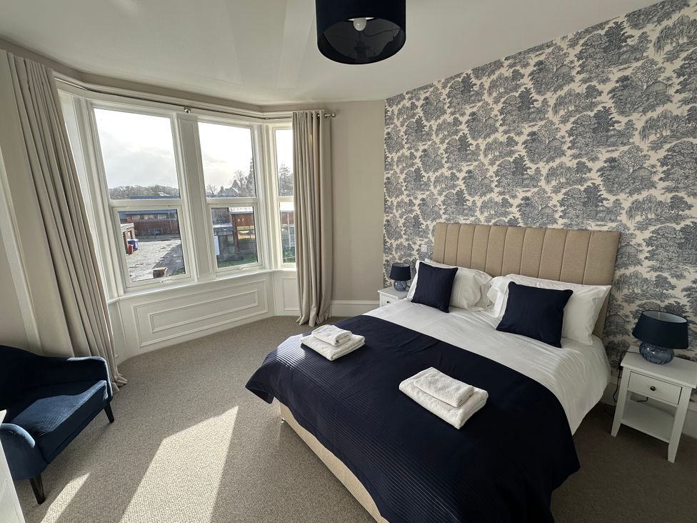 A bedroom with a bed and armchair at Abbotsford in Kelso