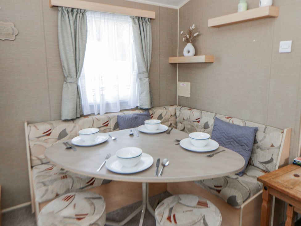 A dining area with a round table and seating at Ger Y Mor in New Quay