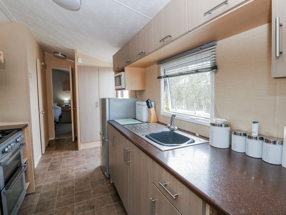 A kitchen with cabinets and appliances at Ger Y Mor in New Quay