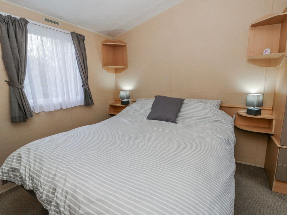 A bedroom with a bed and shelves at Ger Y Mor in New Quay