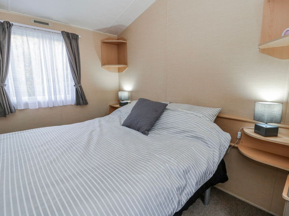 A bedroom with a bed and lamps at Ger Y Mor in New Quay