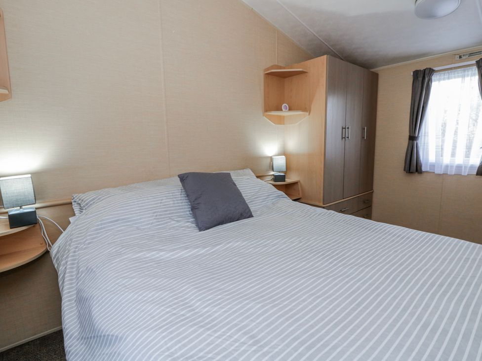 A bedroom with a bed and bedside lamps at Ger Y Mor in New Quay