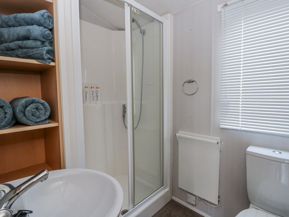 A bathroom with a shower and towels at Ger Y Mor in New Quay