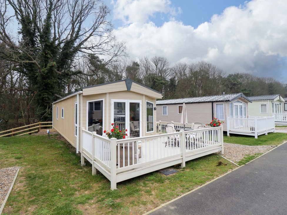 A caravan with a deck and seating area at 108 Fox Burrow Hang in Great Yarmouth