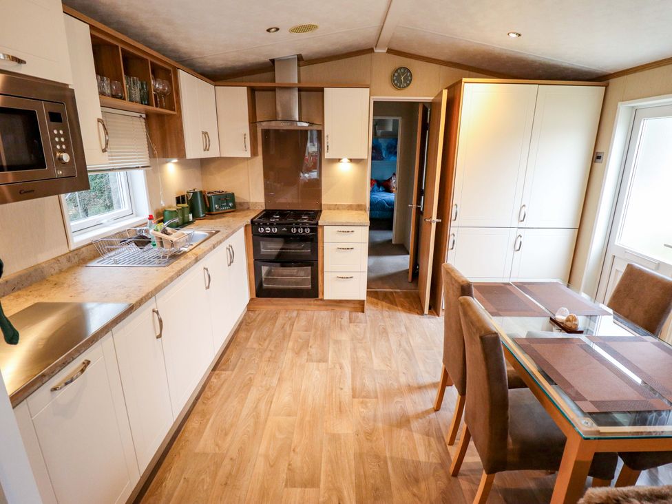 A kitchen with cabinets, countertop, and dining table at 108 Fox Burrow Hang in Great Yarmouth