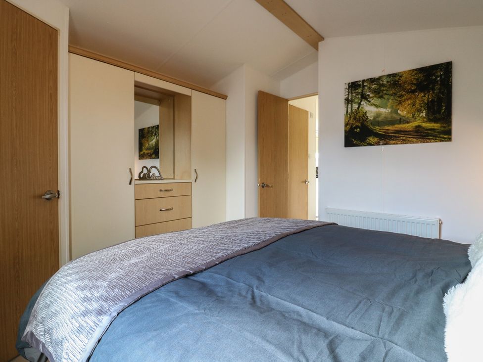 A bedroom with a bed and wardrobe at 2 bed Caravan Stowmarket