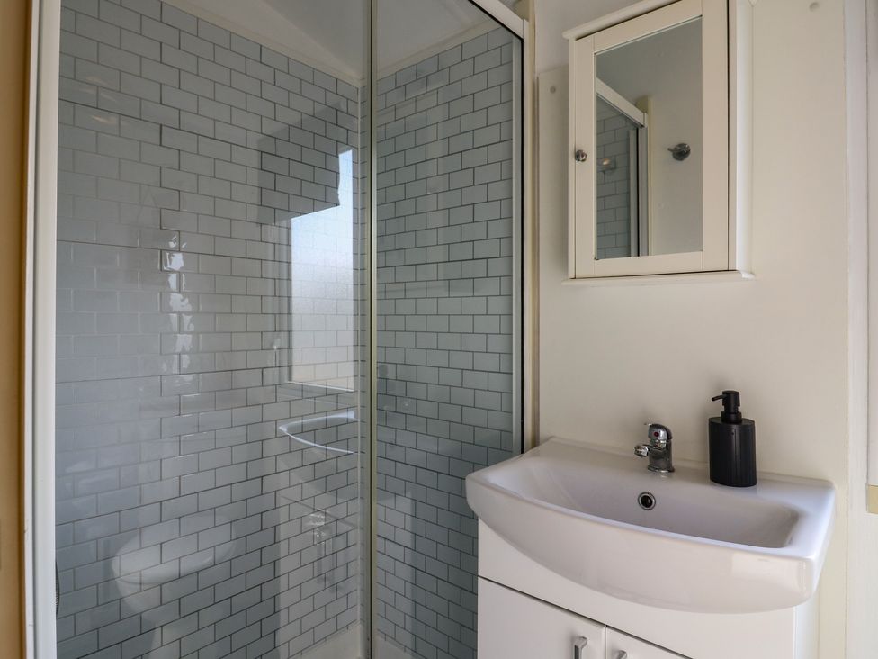 A bathroom with a shower and sink at 2 bed Caravan Stowmarket