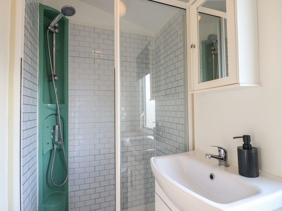 A bathroom with a shower and sink at 2 bed Caravan in Stowmarket