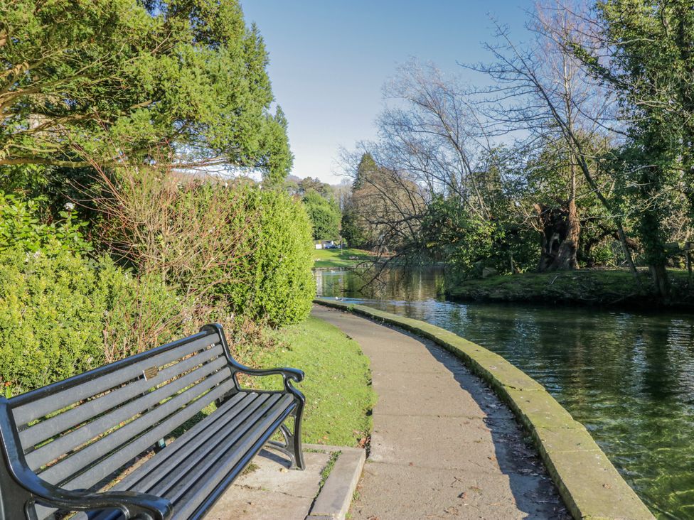 A park with a bench and a path along the water at Linden Lea in Grange-Over-Sands