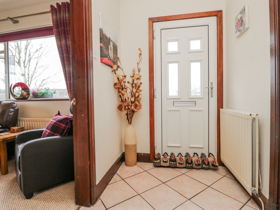 A hallway with a front door and a decorative vase at Linden Lea Field Broughton near Cartmel