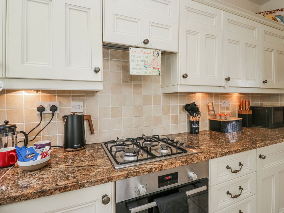 A kitchen with a gas stove and kettle at Linden Lea Field Broughton near Cartmel