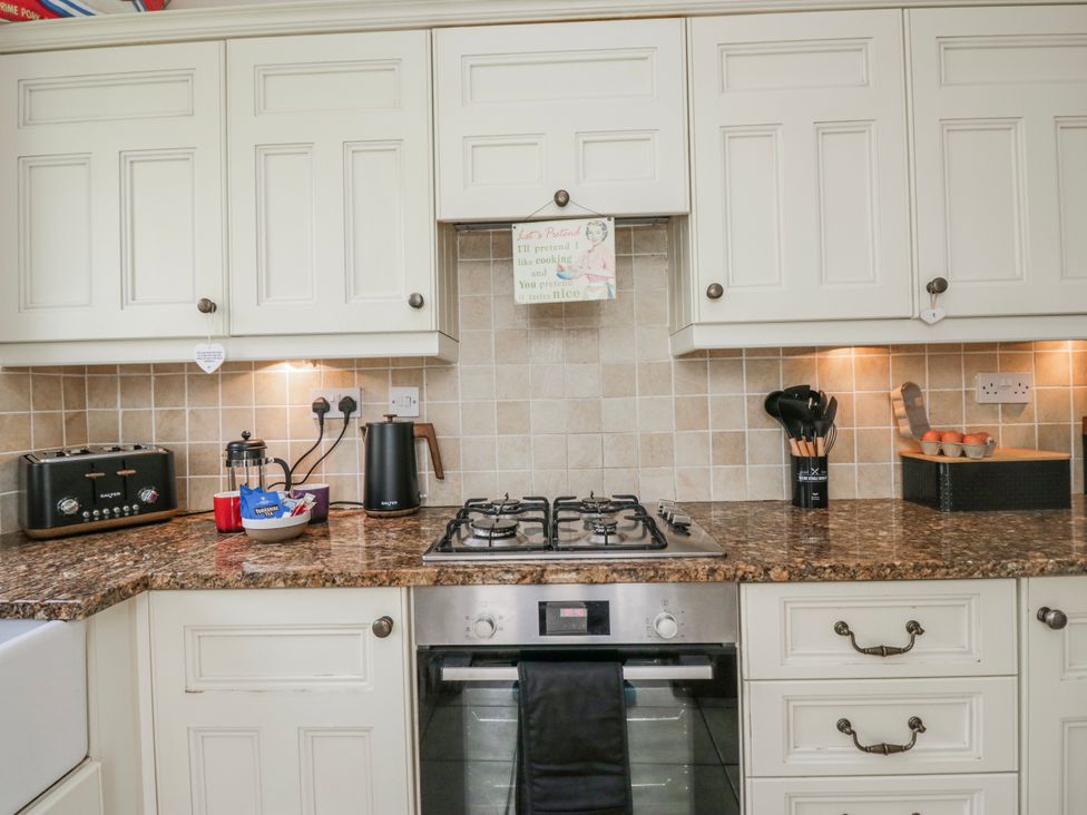 A kitchen with stove and cabinets at Linden Lea Field Broughton near Cartmel