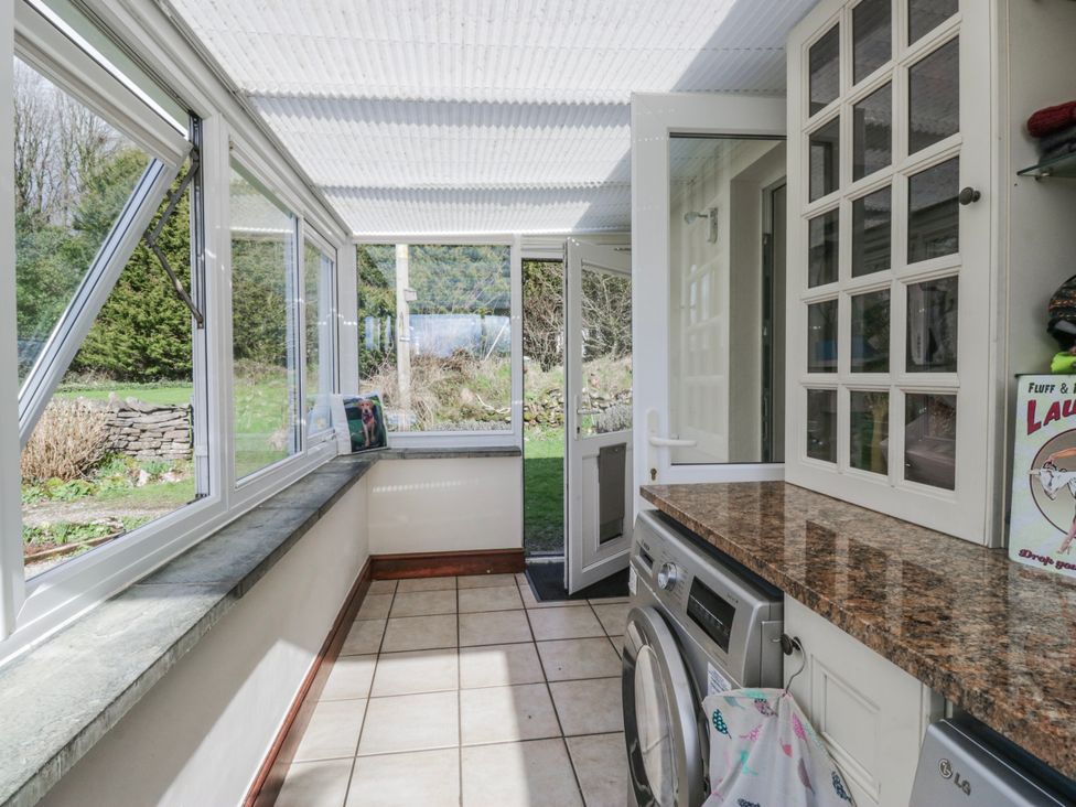 A conservatory with a washing machine and windows at Linden Lea Field Broughton near Cartmel