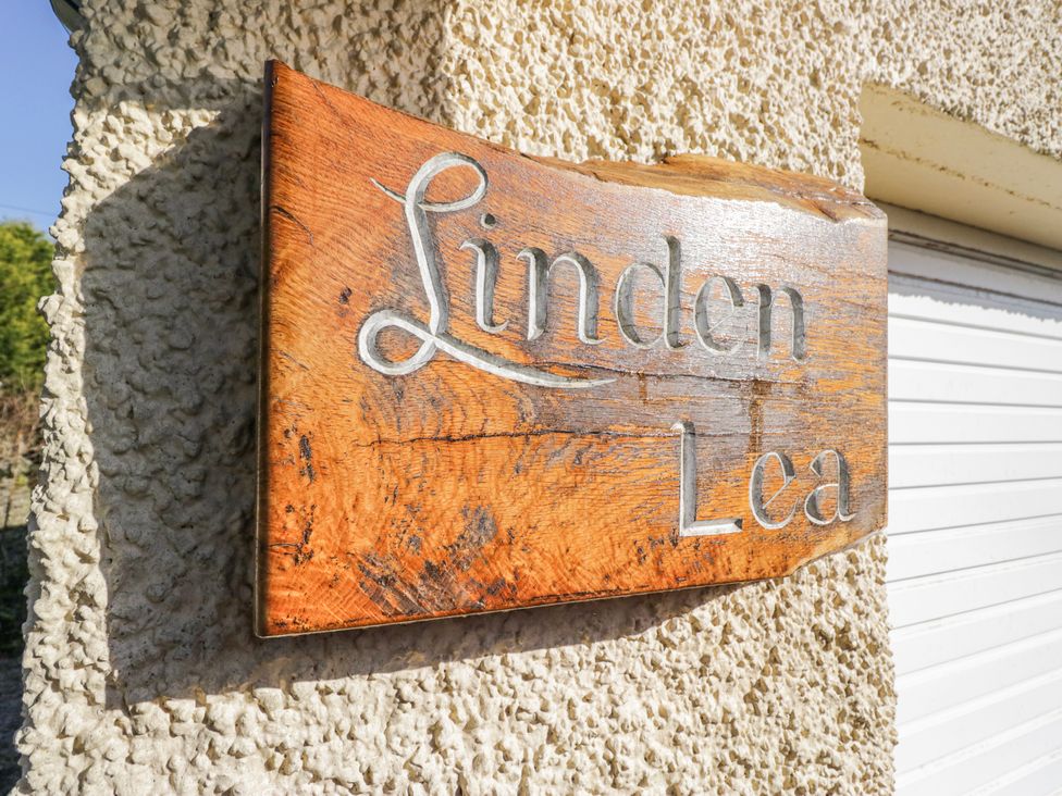 A wooden sign with the name Linden Lea on an exterior wall