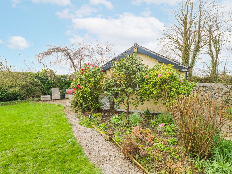 A garden with a house and seating area at Linden Lea Field Broughton near Cartmel