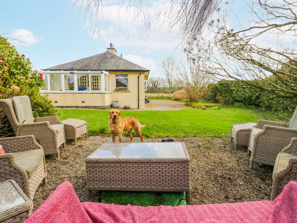 A garden with outdoor seating and a dog at Linden Lea Field Broughton near Cartmel