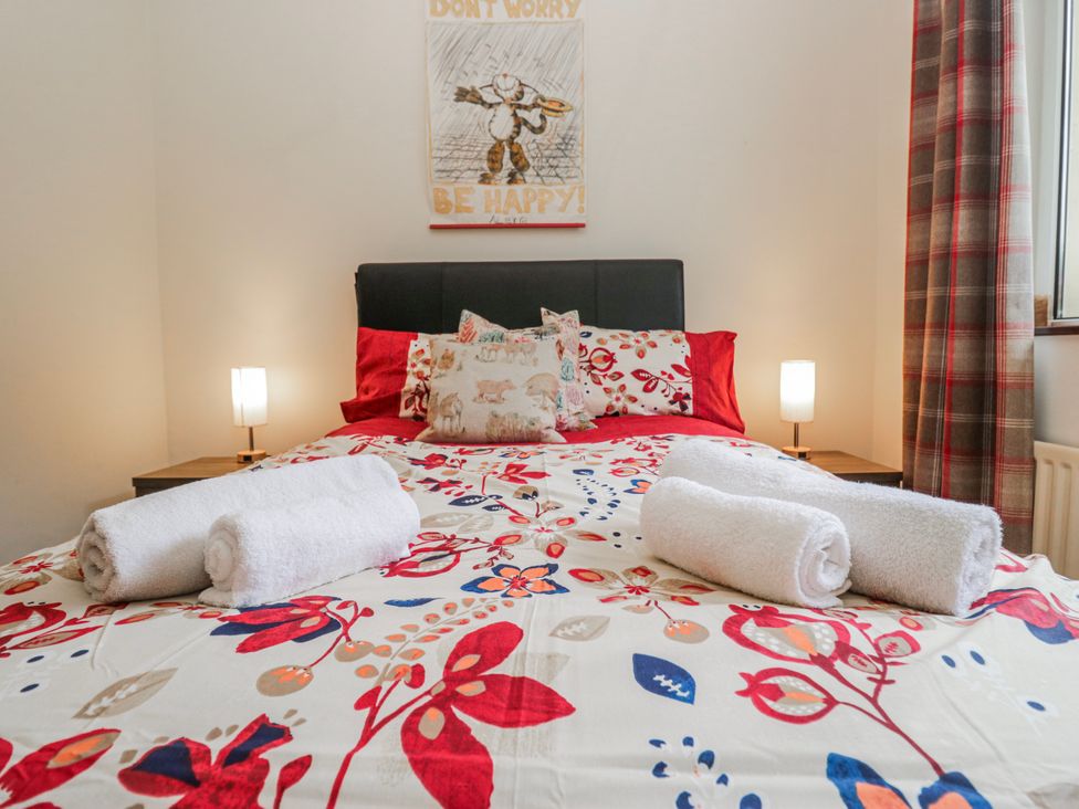 A bedroom with a bed and bedside table at Linden Lea in Field Broughton near Cartmel
