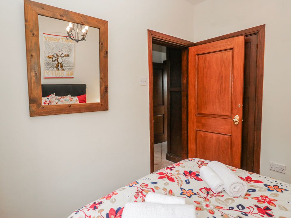 A bedroom with a bed and mirror at Linden Lea Field Broughton near Cartmel
