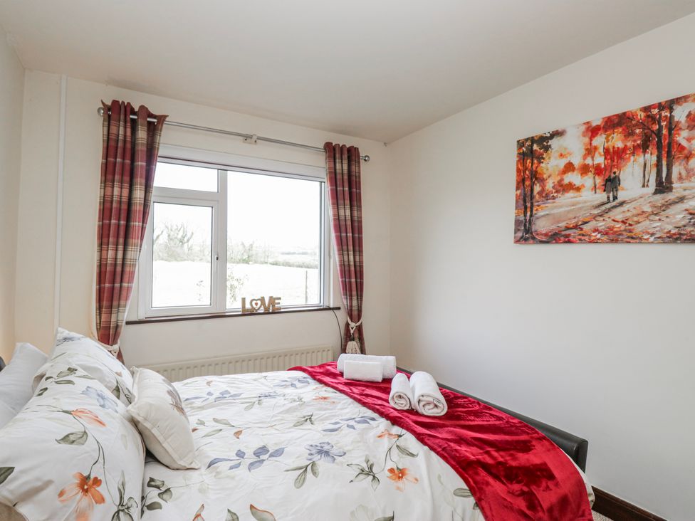 A bedroom with a bed and window at Linden Lea in Field Broughton near Cartmel