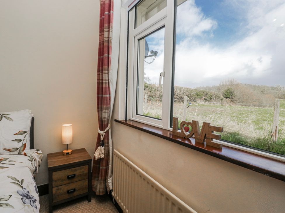 A bedroom with a bed and a lamp at Linden Lea in Field Broughton near Cartmel