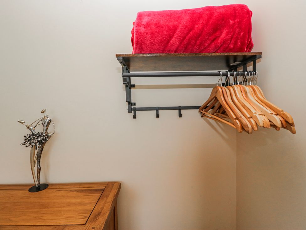 A shelf with a blanket and hangers in a laundry room at Linden Lea Field Broughton near Cartmel