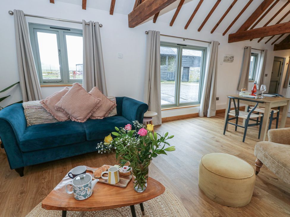 A living room with a coffee table and floral arrangement at Wyn's Barn Nantmel near Rhayader