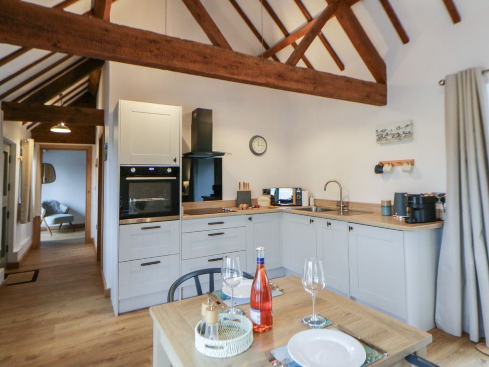 A kitchen with appliances and dining area at Wyn's Barn Nantmel near Rhayader