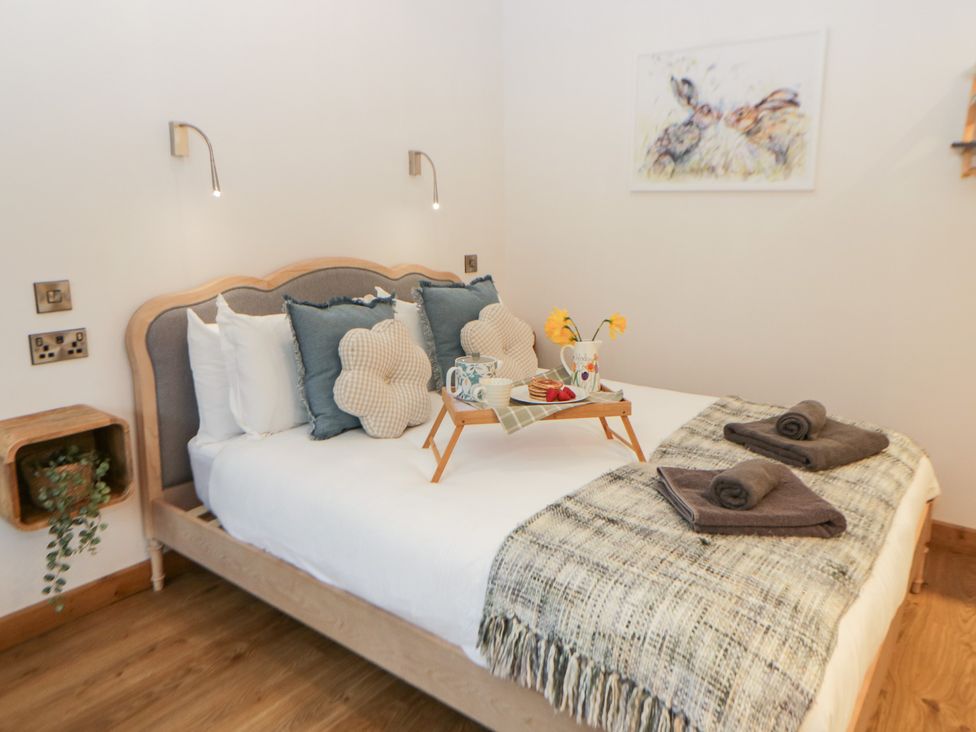 A bedroom with a bed and decorative pillows at Wyn's Barn Nantmel near Rhayader