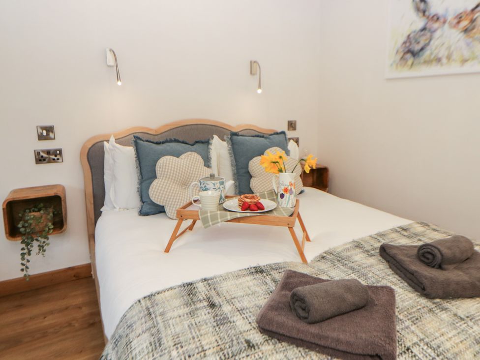A bedroom with a bed and decorative items at Wyn's Barn Nantmel near Rhayader