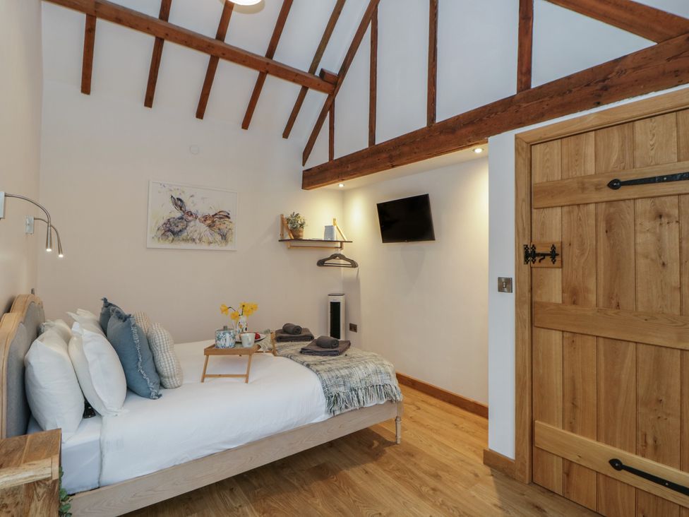 A bedroom with a bed and side table at Wyn's Barn in Nantmel near Rhayader