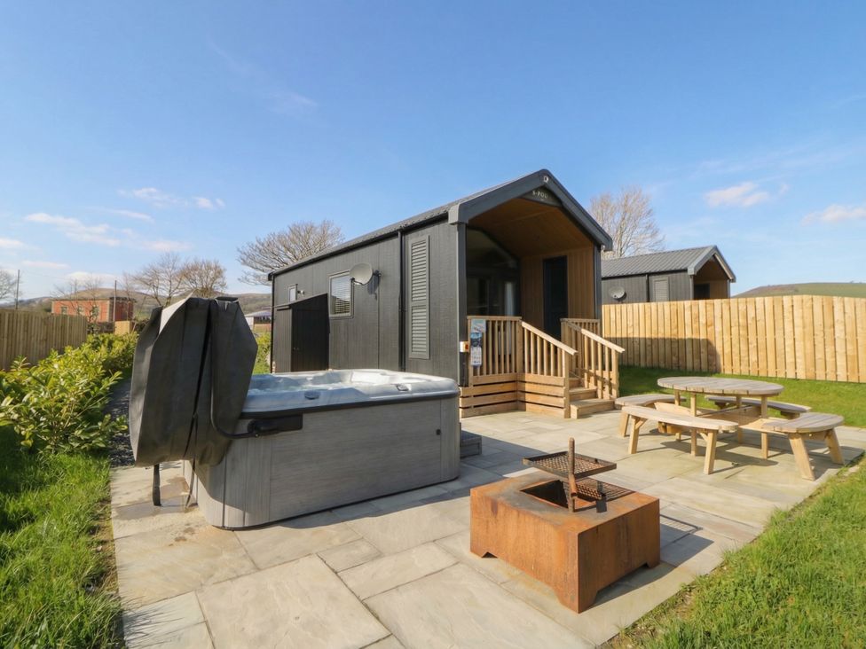 An outdoor area with a hot tub and picnic table at Daverneithon 3 Near Llandrindod Wells