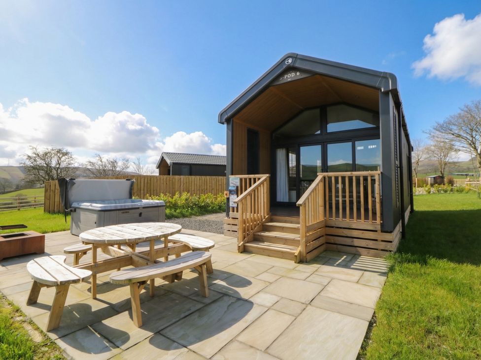 A garden with a table and benches near a hot tub at Daverneithon 3 Near Llandrindod Wells