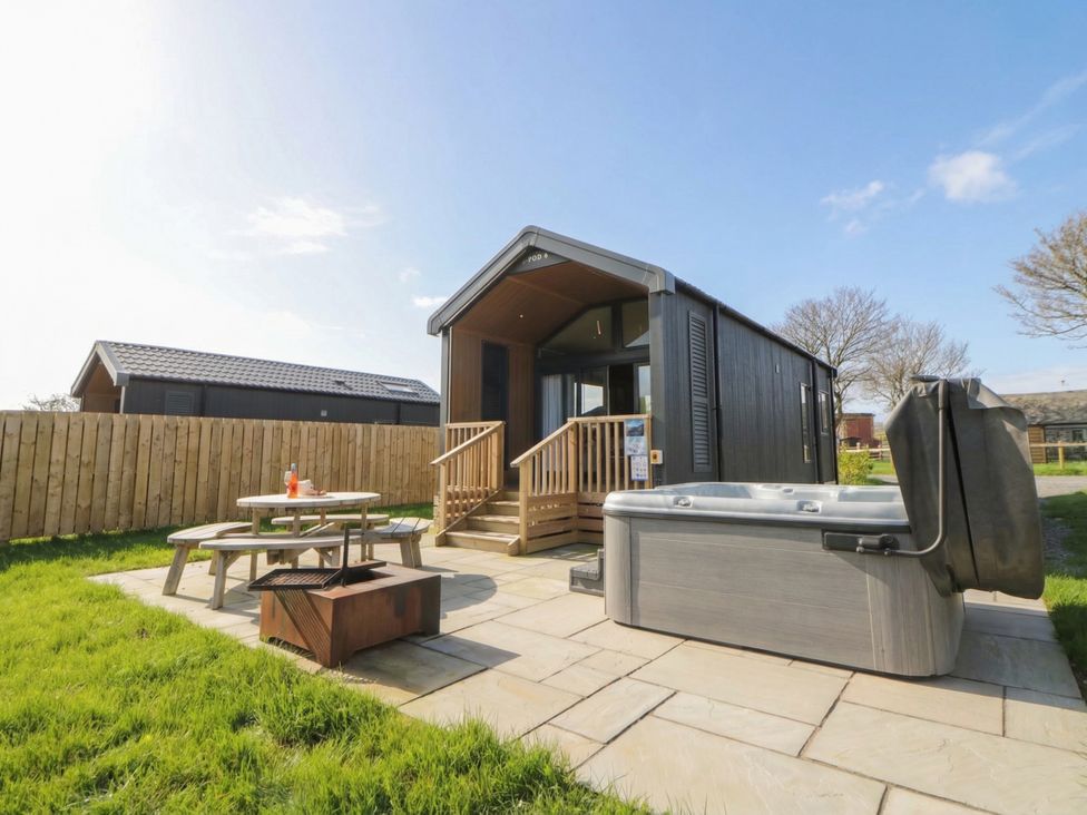 An outdoor area with a hot tub and seating at Daverneithon 4 near Llandrindod Wells