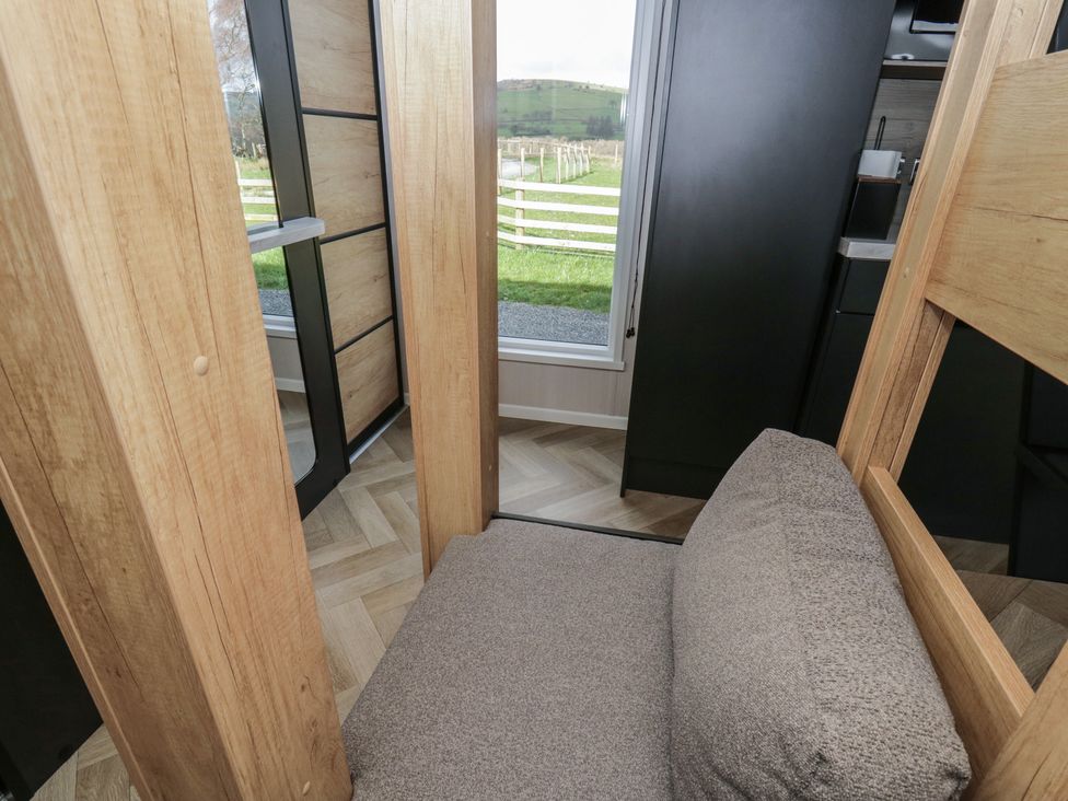A seating area with wood panels and a window at Daverneithon 4 near Llandrindod Wells