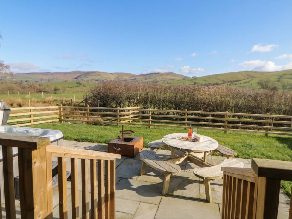 An outdoor seating area with a hot tub and fire pit at Daverneithon 4 near Llandrindod Wells