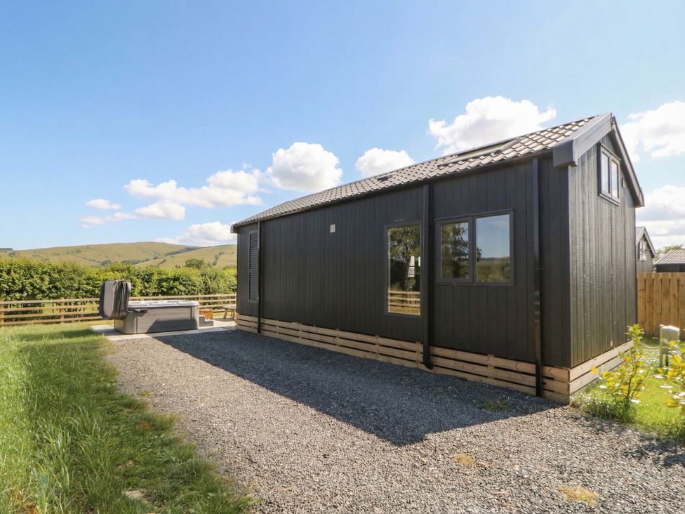 An outdoor area with a hot tub beside a building at Daverneithon 4 near Llandrindod Wells