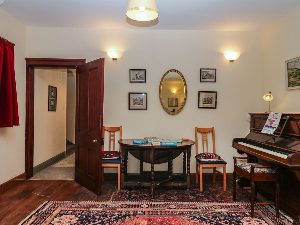 A sitting room with a piano and chairs at Lukesland Wing Ivybridge