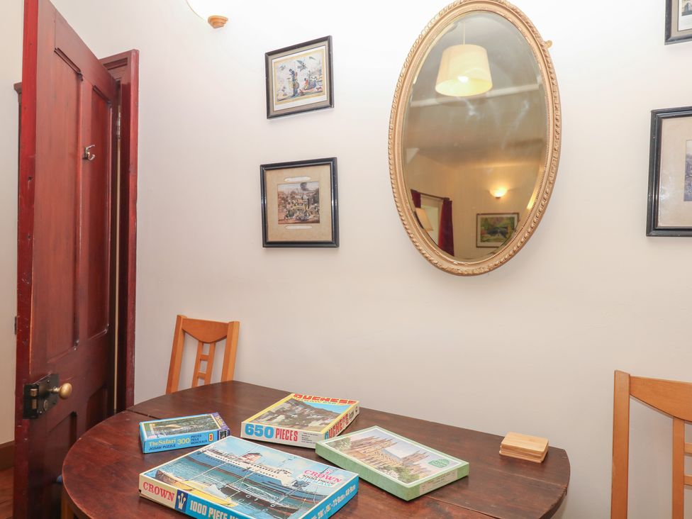 A dining room with a table and puzzle boxes at Lukesland Wing in Ivybridge