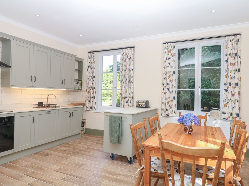 A kitchen with a dining table and chairs at Lukesland Wing in Ivybridge