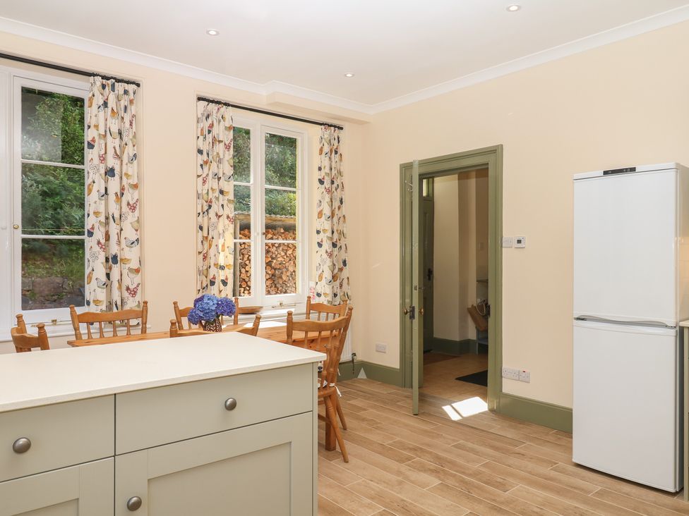A kitchen with a table and chairs at Lukesland Wing in Ivybridge
