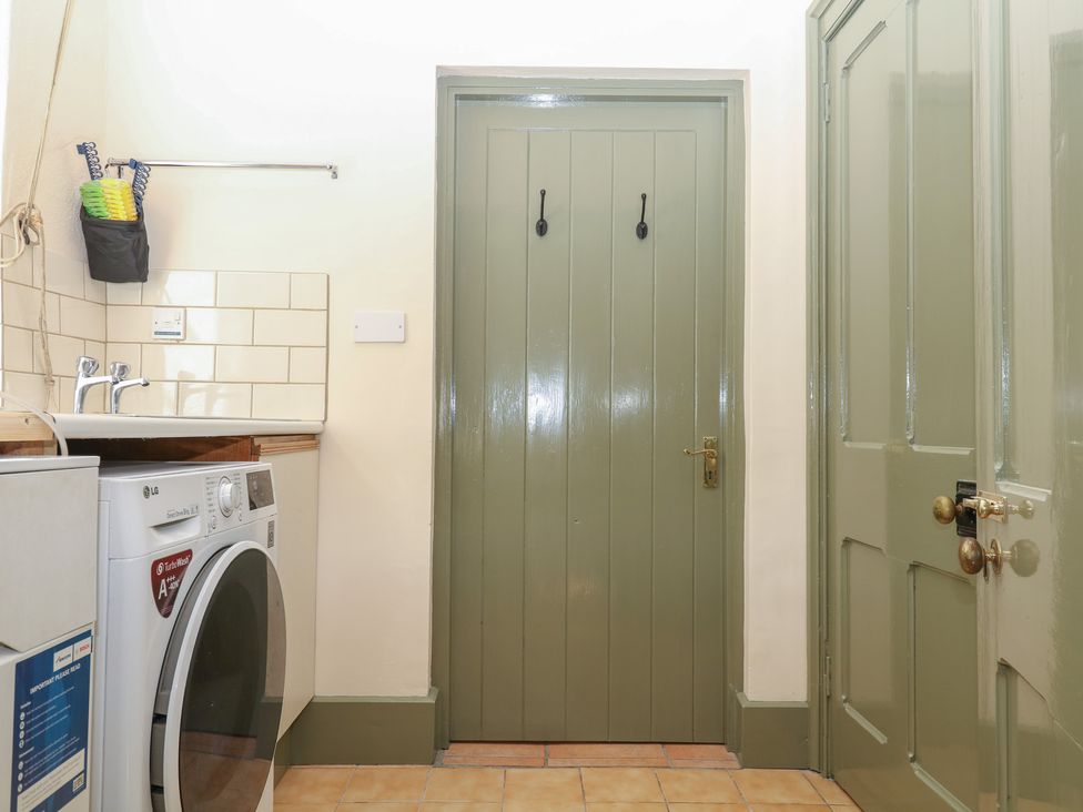 A laundry room with a washing machine and sink at Lukesland Wing in Ivybridge