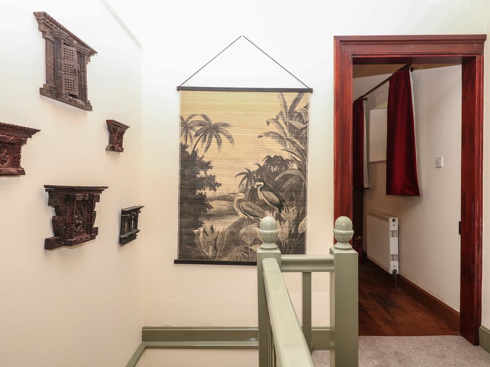 A hallway with wall art and wooden decor at Lukesland Wing in Ivybridge